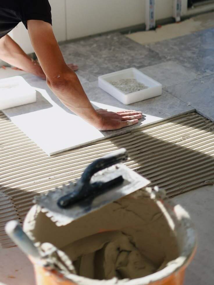 Pose de carrelage grand format sur colle peignée