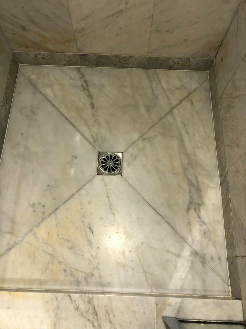 Receveur de douche en marbre, salle de bain rénovée avec évacuation centrale